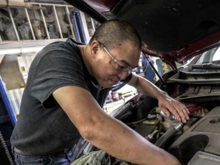 man working on car motor