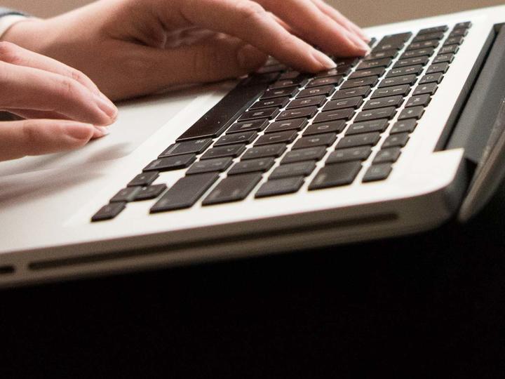Hands on a laptop keyboard