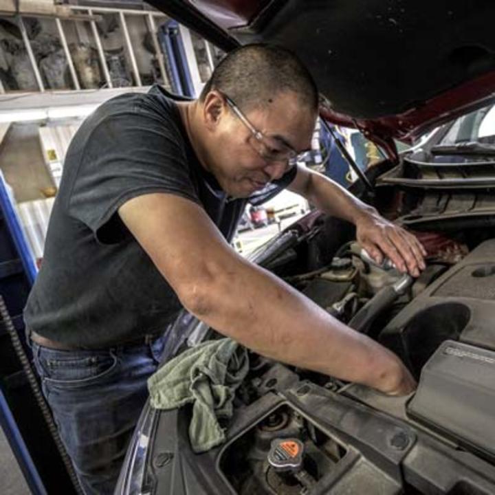 man working on car motor